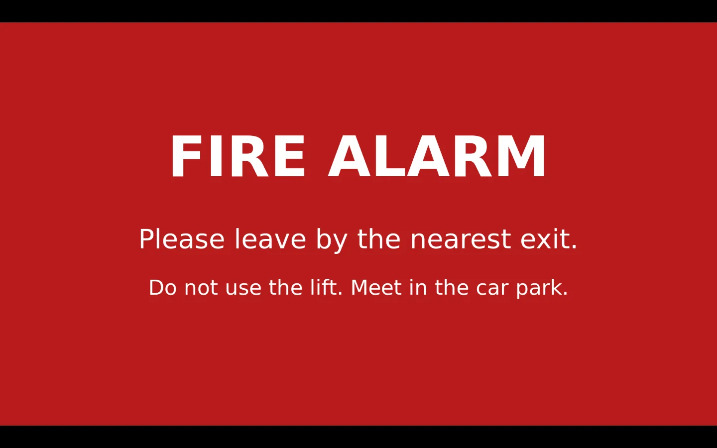 A screen showing a red full-screen notice: FIRE ALARM. Please leave by the nearest exit. Do not use the lift. Meet in the car park.
